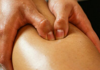 Close-up of hands applying pressure on a leg during a therapeutic massage session.
