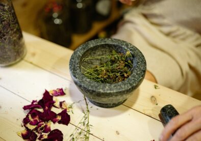 Close-up of dried herbs in a mortar and pestle for natural healing.