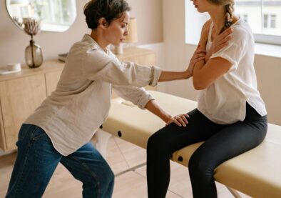 A therapist assists a patient during a physical therapy session indoors.