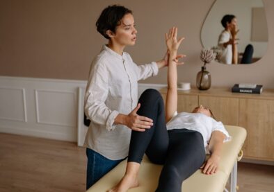 A therapist assists a patient during a physical therapy session indoors, focusing on rehabilitation.