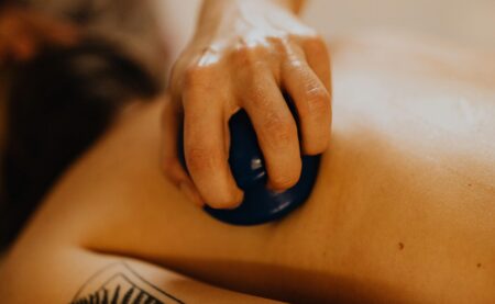 A calming massage session with a focus on relaxation using a massage cup on a tattooed back.